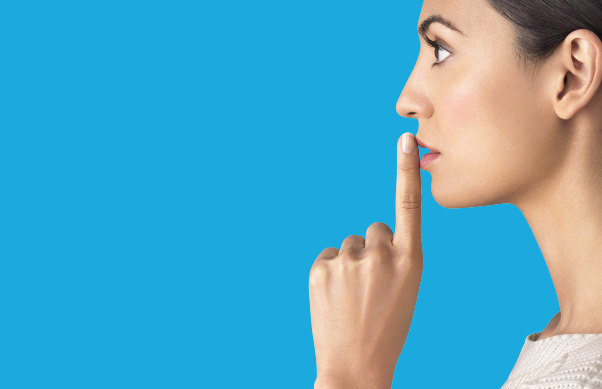Woman placing finger on mouth to reflect silence