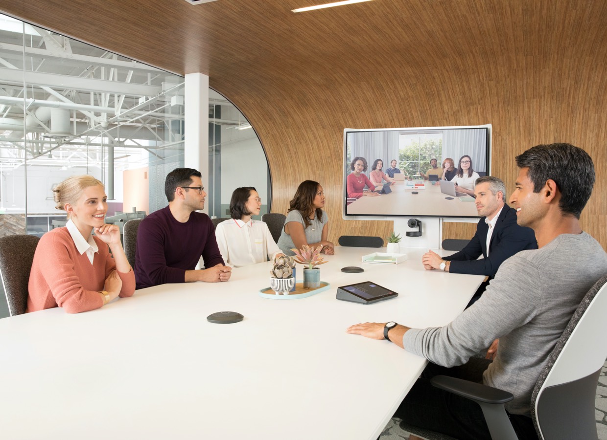 Pessoas em reunião com sistema HP e soluções para sala grande Logitech Tap
