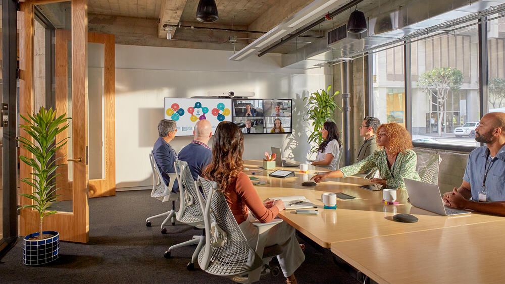 People at conference table video conferencing