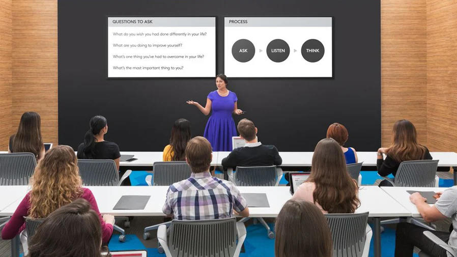 Professora dando palestra a alunos enquanto usam a colaboração por vídeo