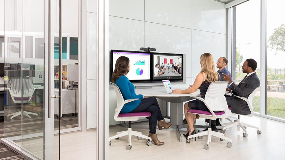 People in a huddle room web conferencing