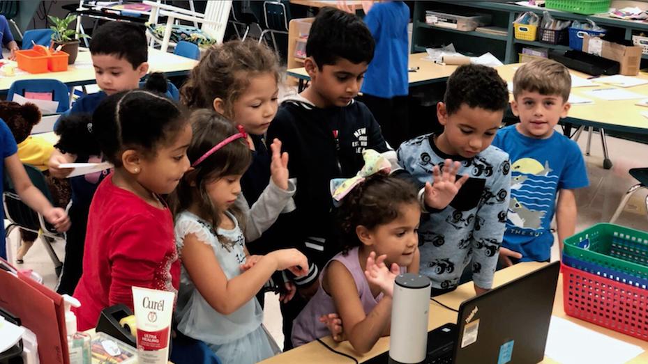 Kinder, die während einer Videokonferenz auf einen Computer schauen