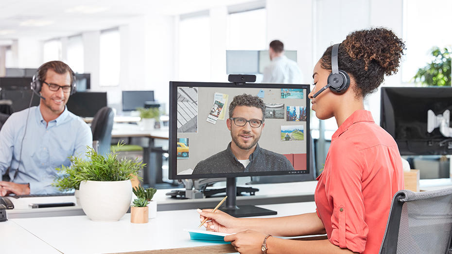 Mujer trabajando en oficina y videoconferencia con audífonos inalámbricos