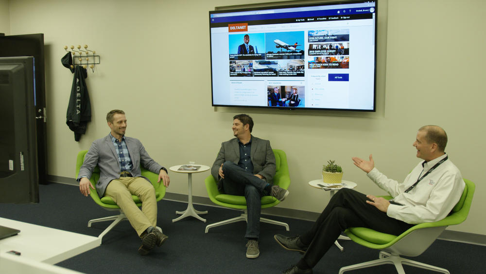 People at conference table video conferencing